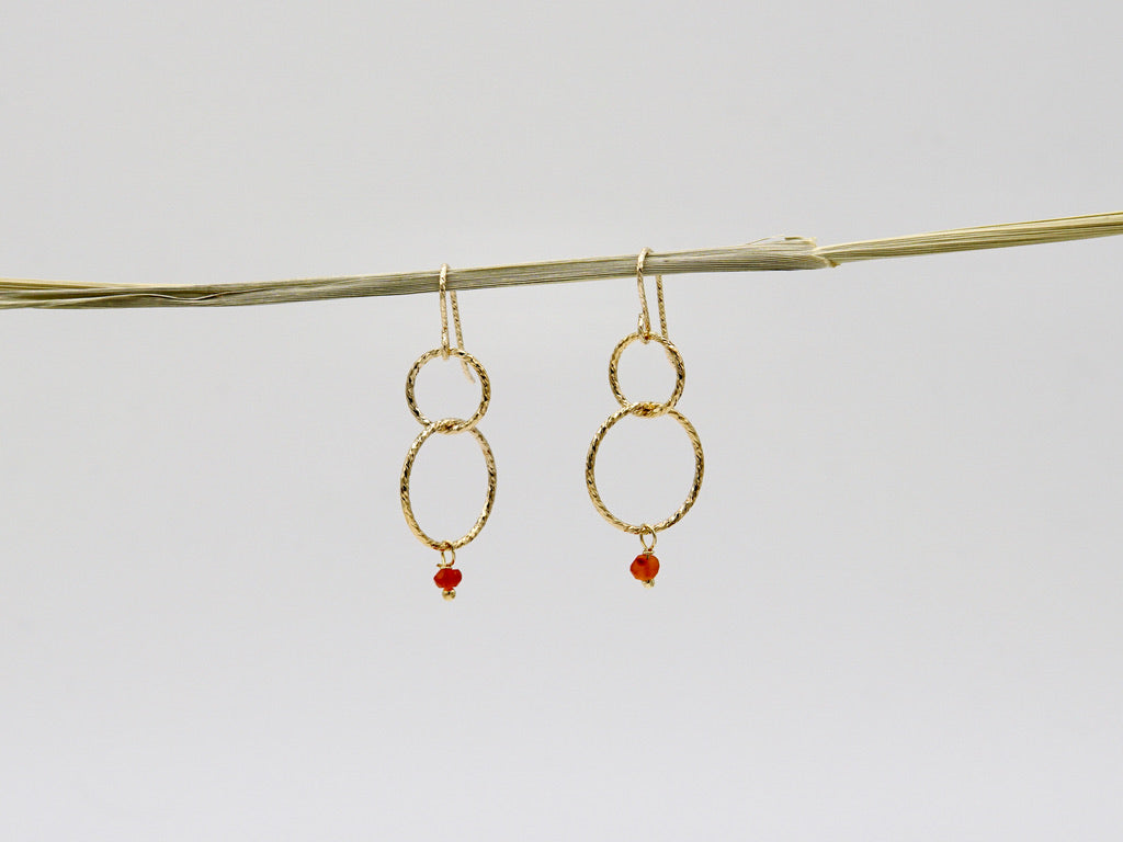 Hängende LISETTE Ohrringe aus 14 Karat Goldfilled, fein gearbeitete ineinander verschlungene Ringe mit leuchtend rotem Karneol-Anhänger, Design von Femelle Anouk