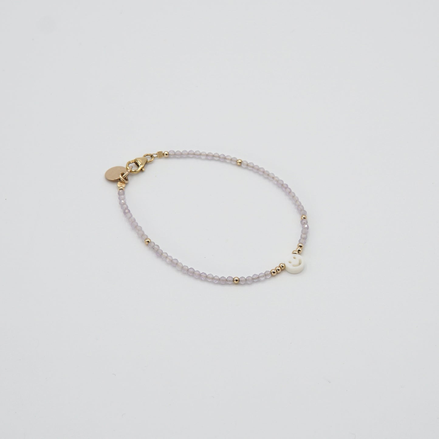 Zarte, violette Amethystperlen des 'SMILE'-Armbands, die dezente Eleganz ausstrahlen.