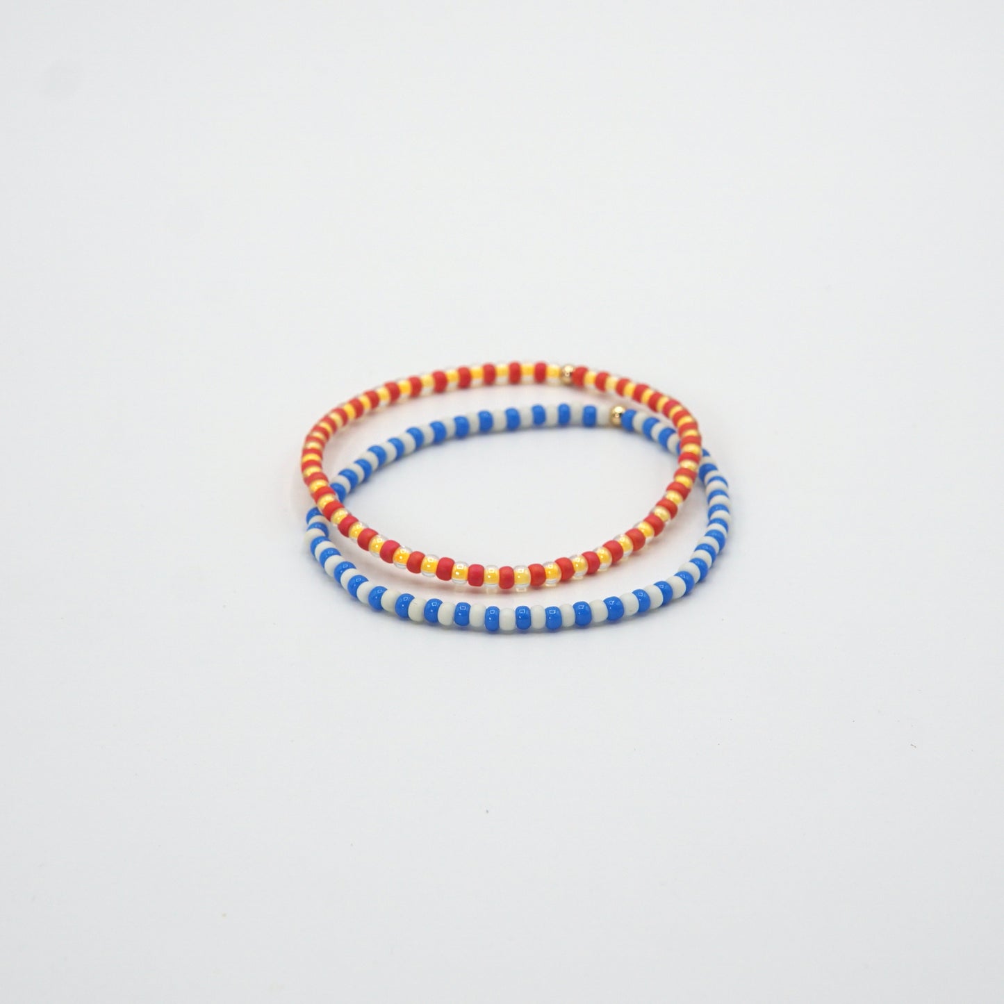 Elastische 17,5 cm lange Armbänder NAGOMI mit kontrastierenden Glasperlen und einer zarten 14-Karat-Goldfilled-Perle.