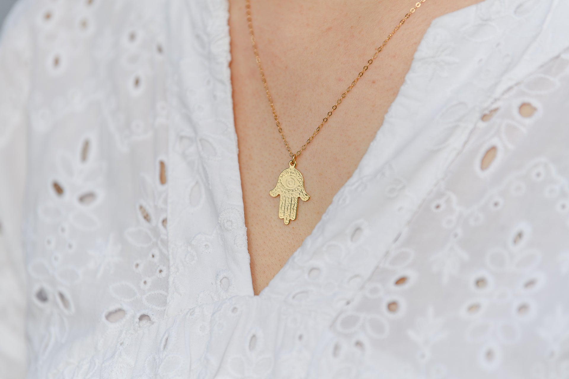 Modell trägt die Kette FATIMA mit Hamsa-Hand-Anhänger, elegantes und bedeutungsvolles Accessoire für verschiedene Anlässe