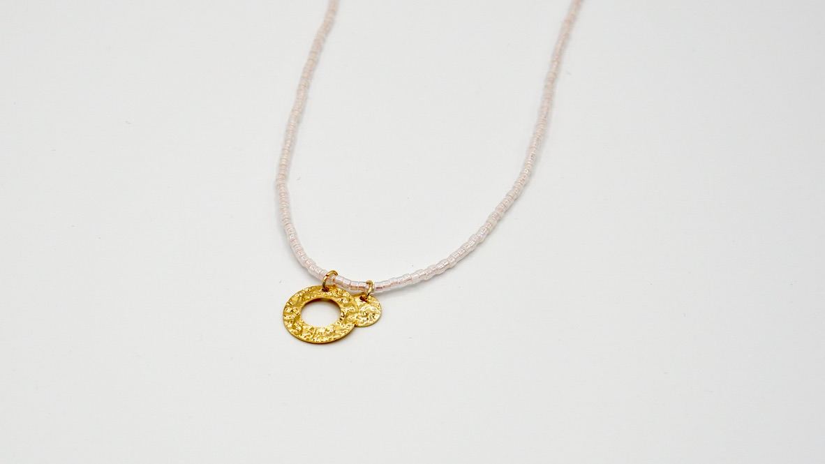 Nahaufnahme der beweglichen goldenen Plättchen auf der Kette VERONIQUE, zeigt die elegante Einfachheit und flexible Anordnung