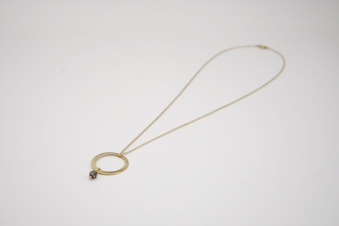 Nahaufnahme des Ring-Anhängers und der zarten Labradorit-Perle der Kette ROUE, zeigt die feine Handwerkskunst und das zeitlose Design