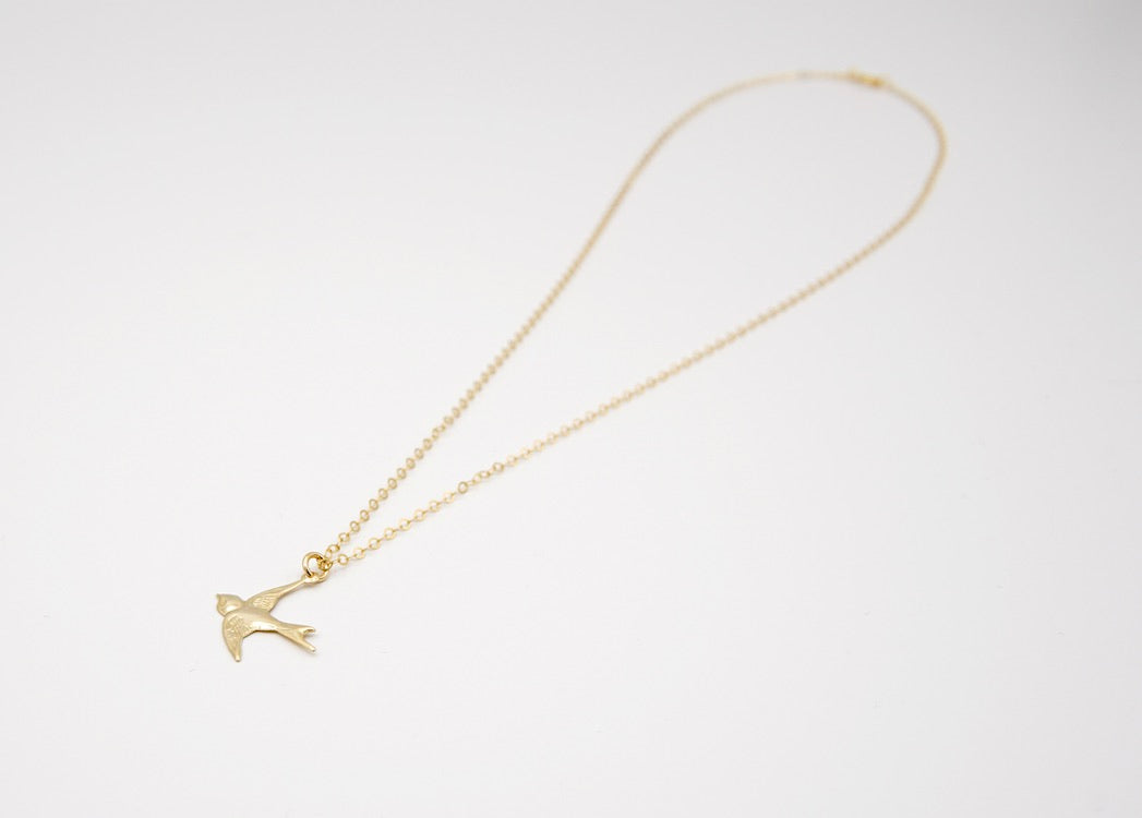 Nahaufnahme des Schwalbenanhängers der Kette HIRONDELLE, zeigt die feine Handwerkskunst und das symbolträchtige Design