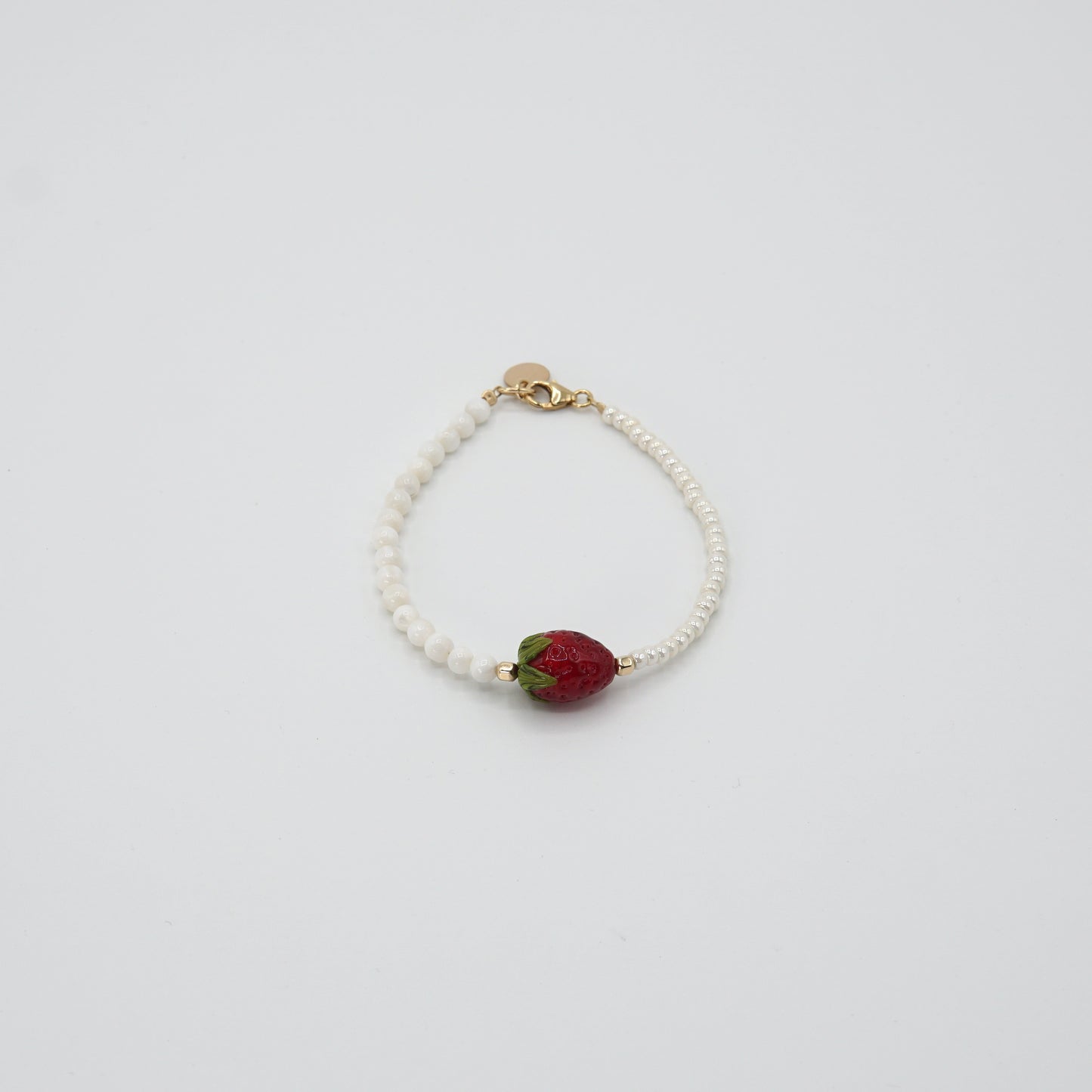 Detailansicht der handgearbeiteten Glasperle des 'STRAWBERRY BABE'-Armbands, umgeben von feinen Glas- und Perlmuttperlen.