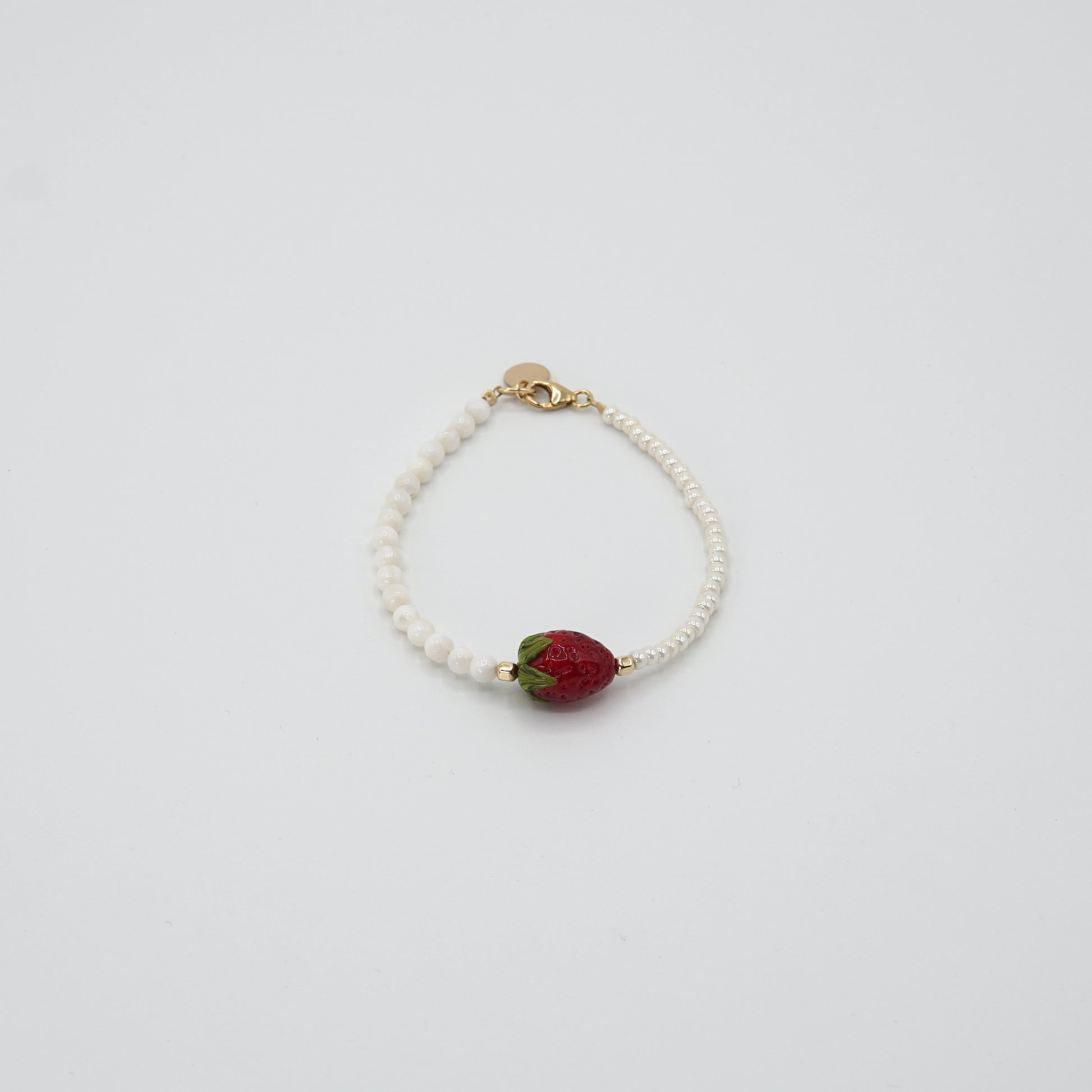 Detailansicht der handgearbeiteten Glasperle des 'STRAWBERRY BABE'-Armbands, umgeben von feinen Glas- und Perlmuttperlen.
