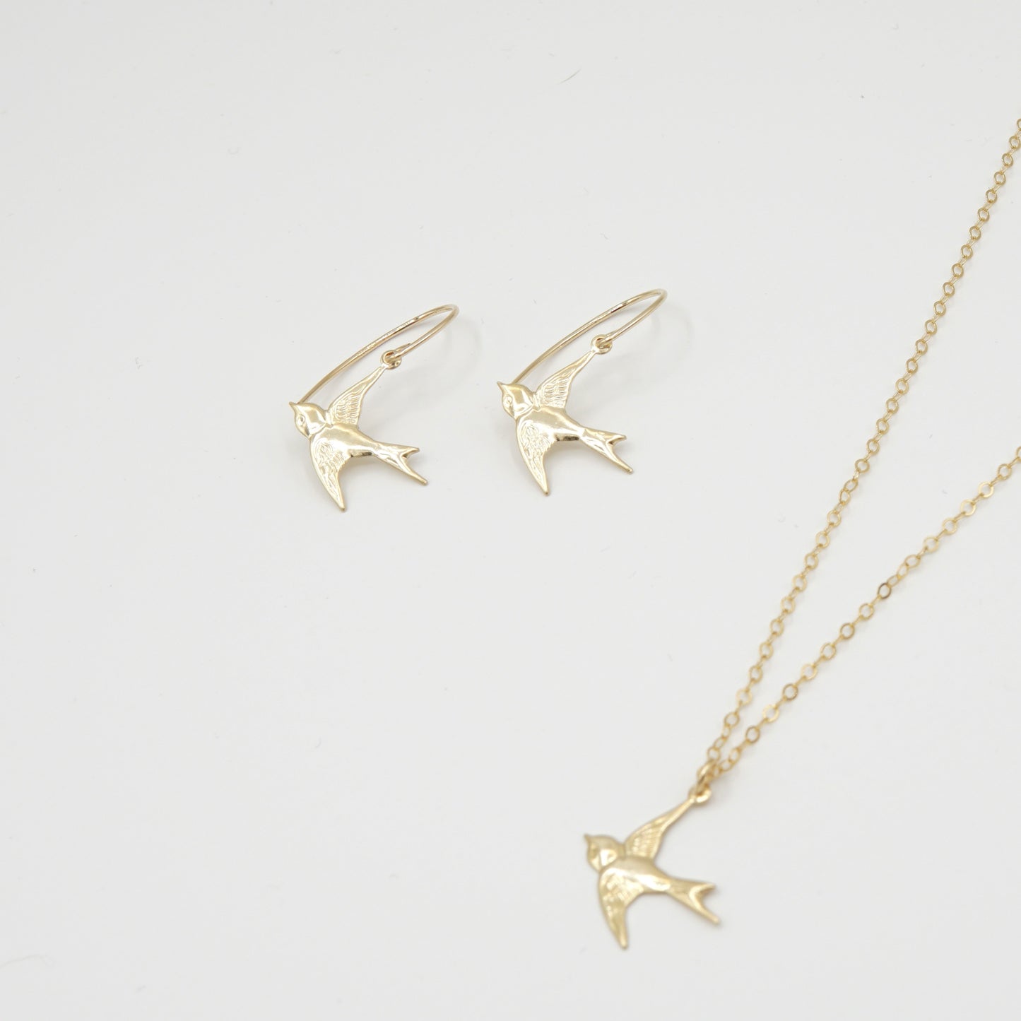 Ohrringe und Halskette HIRONDELLE von Femelle Anouk: Filigrane Schwalben-Anhänger aus 14 Karat Goldfilled, handgefertigt und nickelfrei.