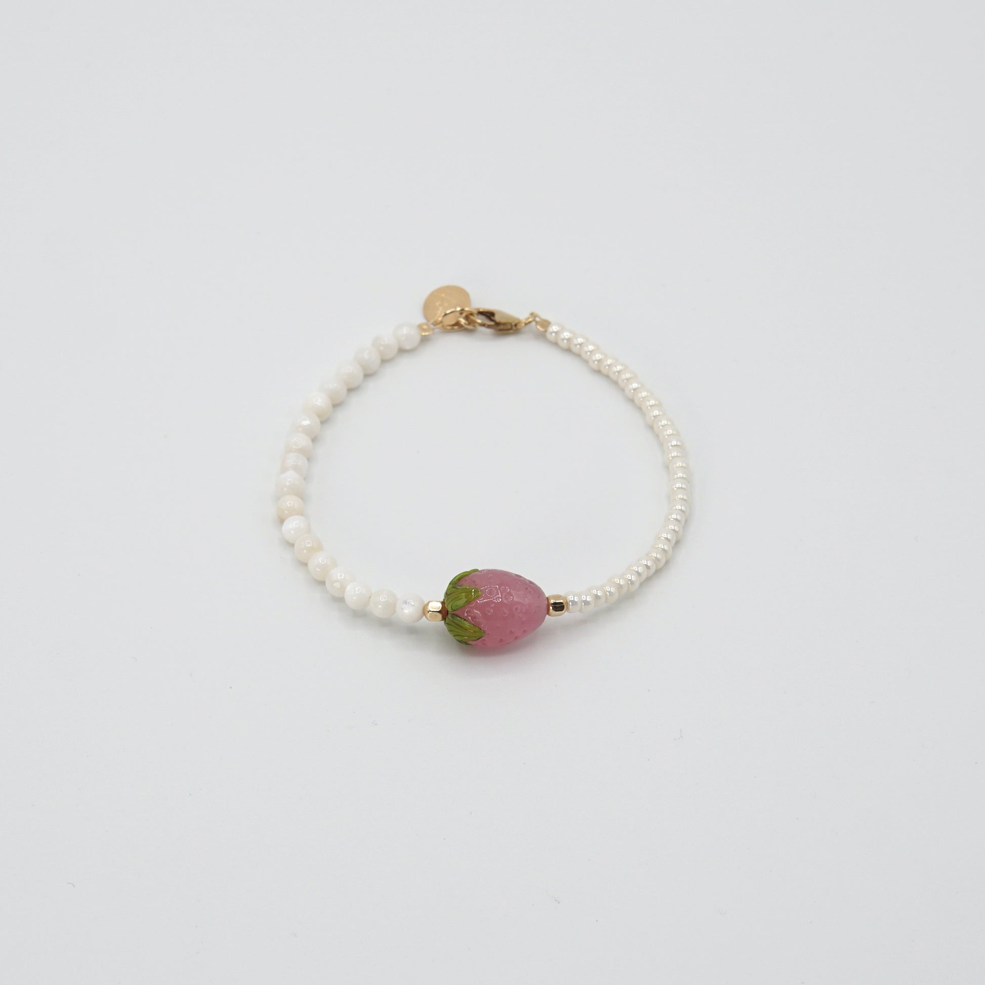 Detailansicht der handgearbeiteten Glasperle des 'STRAWBERRY BABE'-Armbands, umgeben von feinen Glas- und Perlmuttperlen.