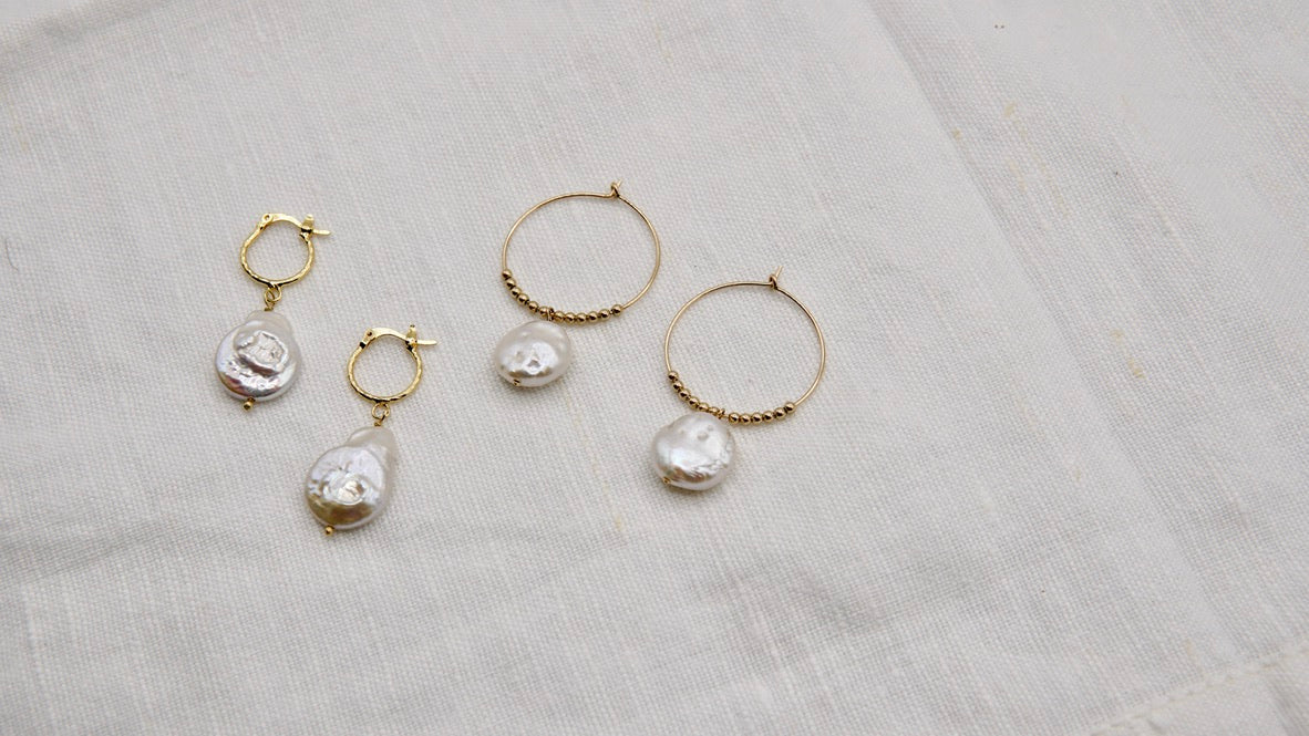 Nahaufnahme der Ohrringe COLETTE und Creolen, zeigt die feine Handwerkskunst und das minimalistische Design aus 14 Karat Goldfilled.