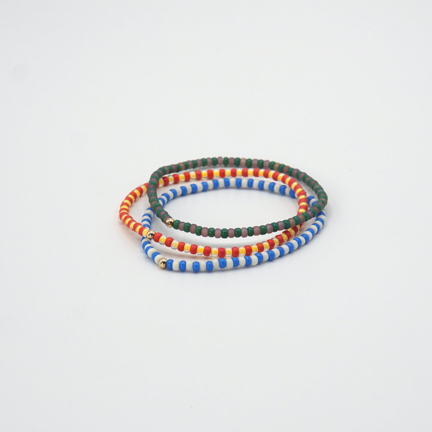 3 verschiedene Elastische 17,5 cm lange Armbänder NAGOMI mit kontrastierenden Glasperlen und einer zarten 14-Karat-Goldfilled-Perle.