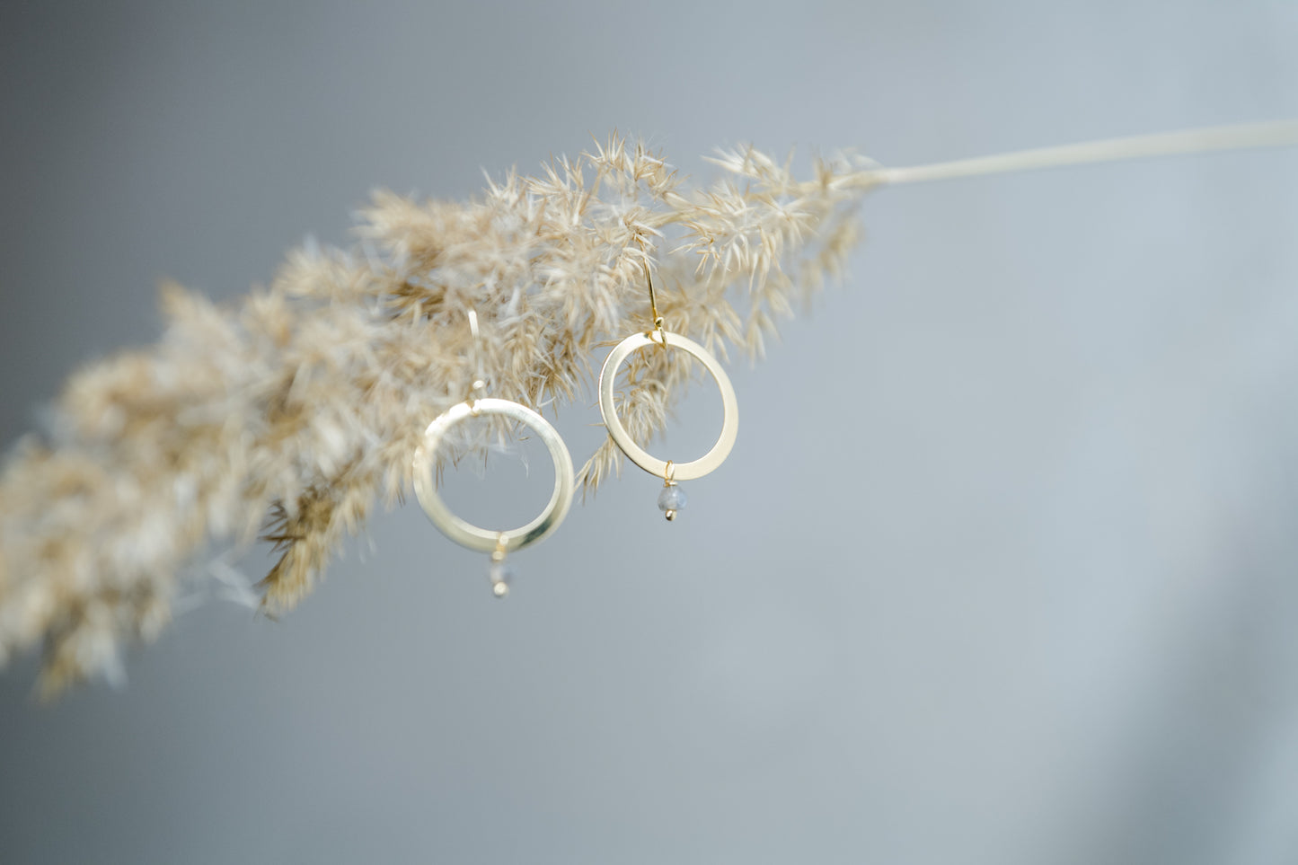 Handgefertigte Creolen aus 14 Karat Goldfilled mit Labradorit-Perle – filigrane Ohrringe vor naturinspirierter Kulisse