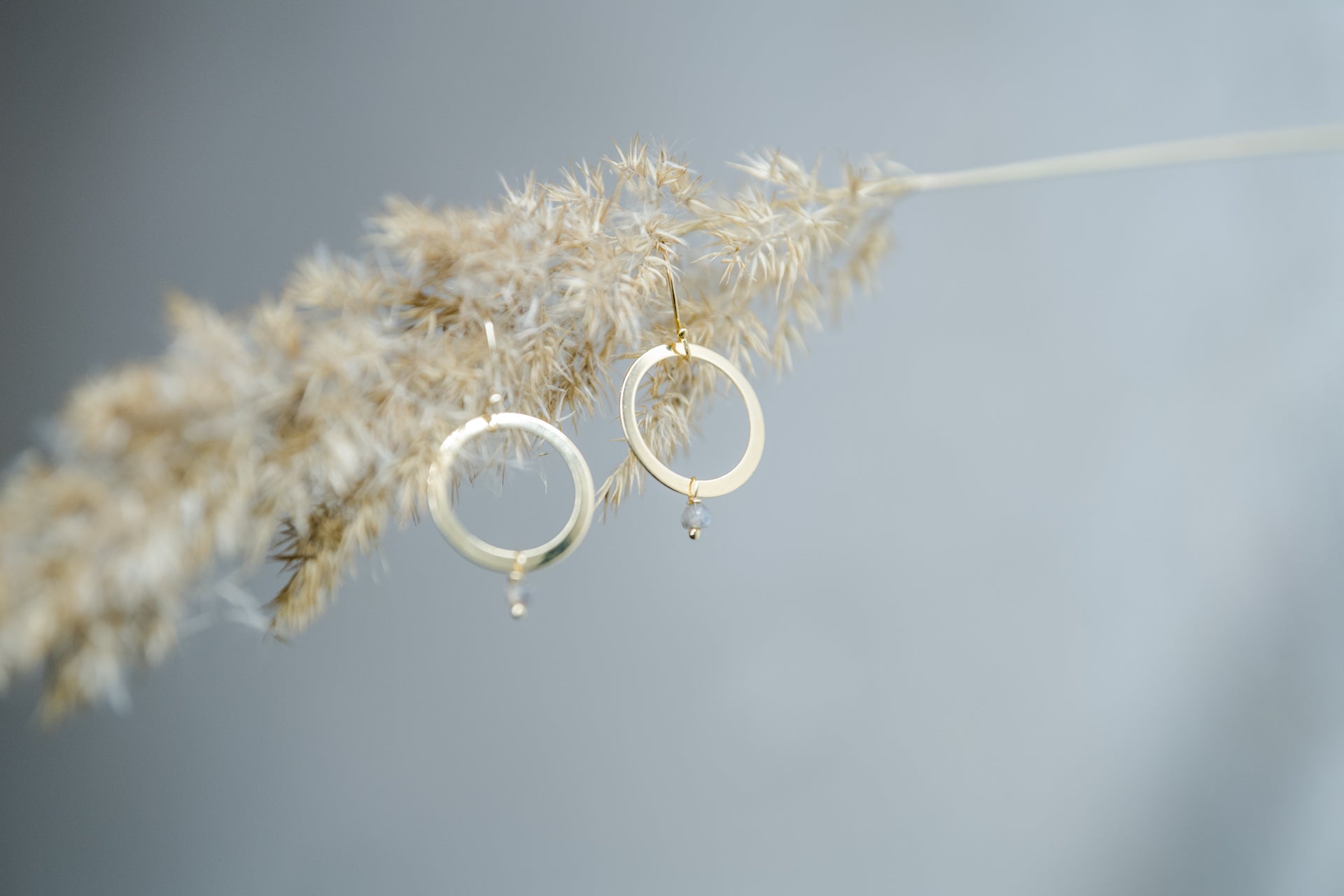 Handgefertigte Creolen aus 14 Karat Goldfilled mit Labradorit-Perle – filigrane Ohrringe vor naturinspirierter Kulisse