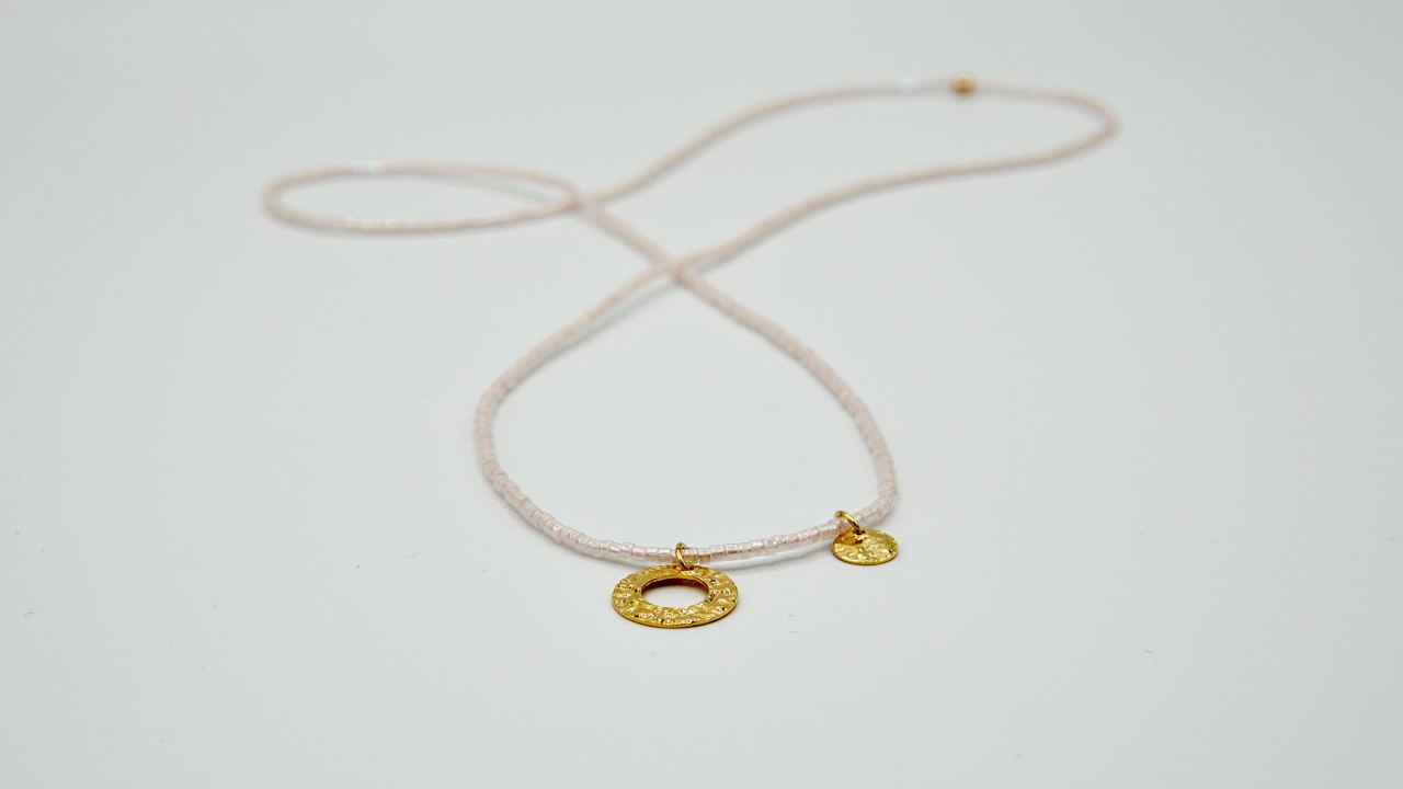 Nahaufnahme der beweglichen goldenen Plättchen auf der Kette VERONIQUE, zeigt die elegante Einfachheit und flexible Anordnung