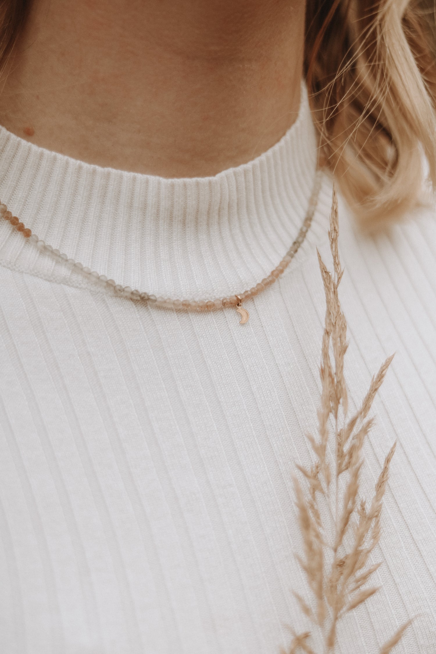 Modell trägt die Kette LUNA mit schimmernden Mondstein-Perlen und kleinem Mond-Anhänger, verleiht dem Look eine mystische Aura