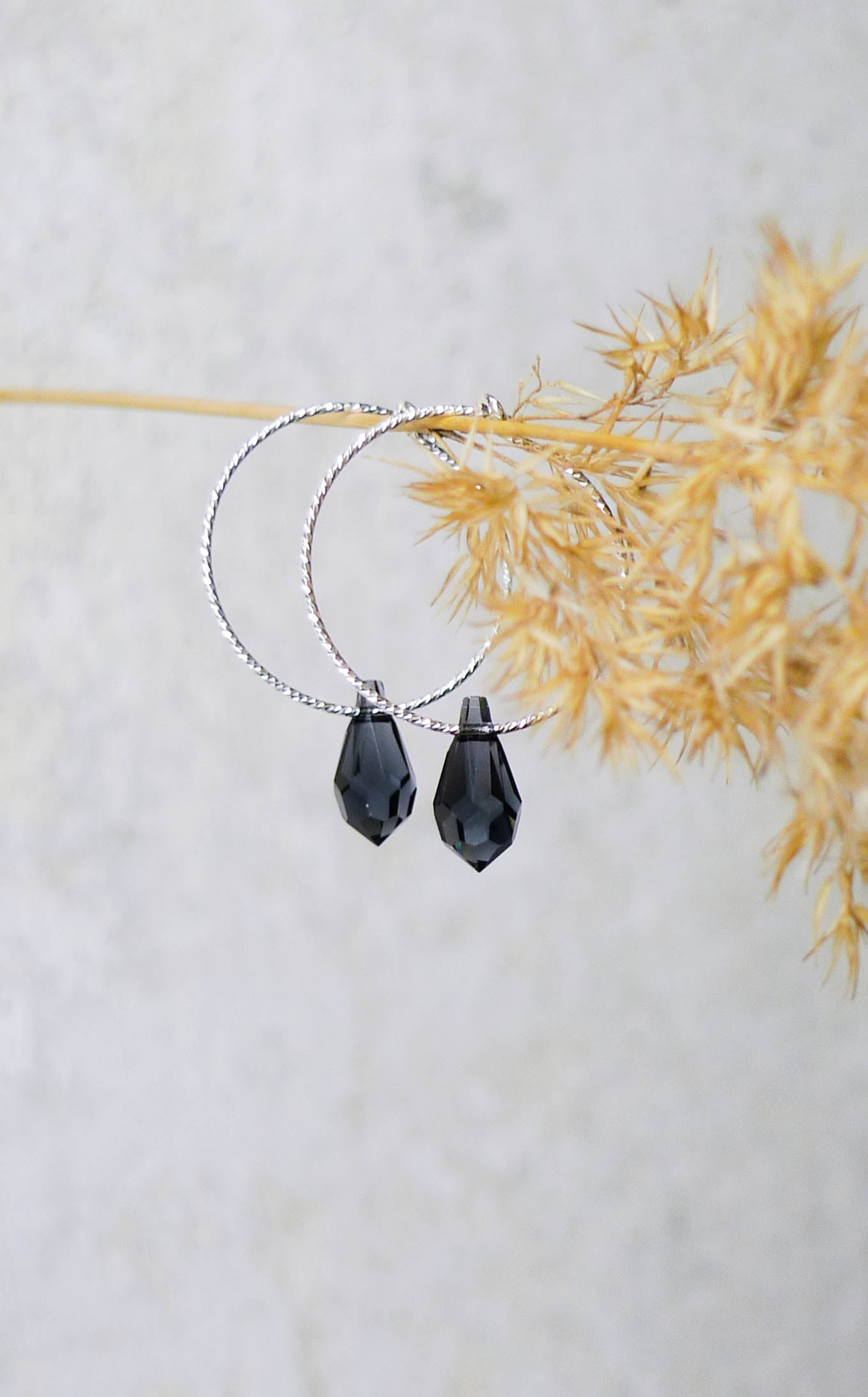 Detailansicht des tropfenförmigen Swarovski-Kristalls, der an der Creole 'CÉLINE' hängt und für besonderen Glanz sorgt.